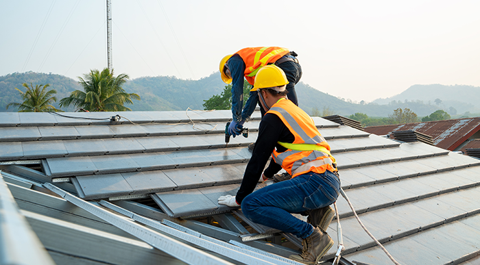 Two employees working on a roof.
