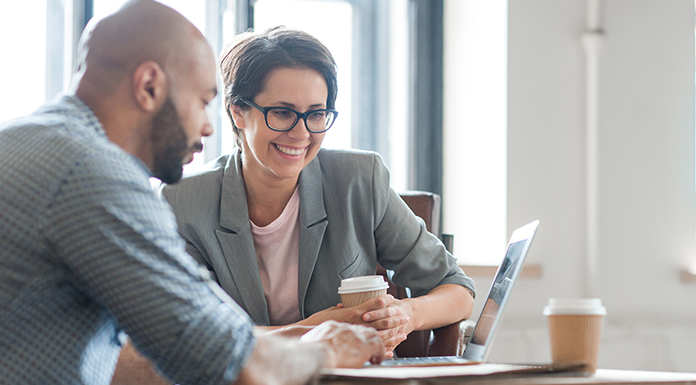 Agent and business owner reviewing workers comp insurance policy