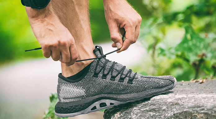 An aging worker tying his running shoe.