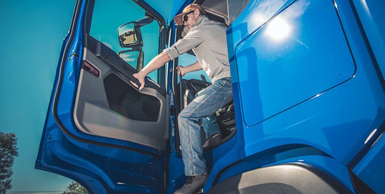 A driver safely existing his truck.