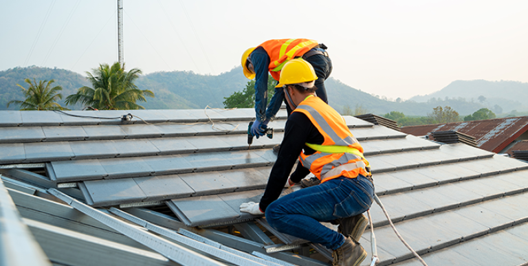 Two employees working on a roof.