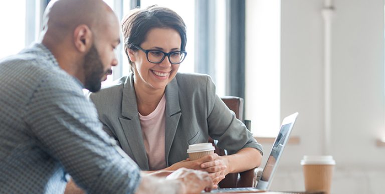 Agent and business owner reviewing workers comp insurance policy