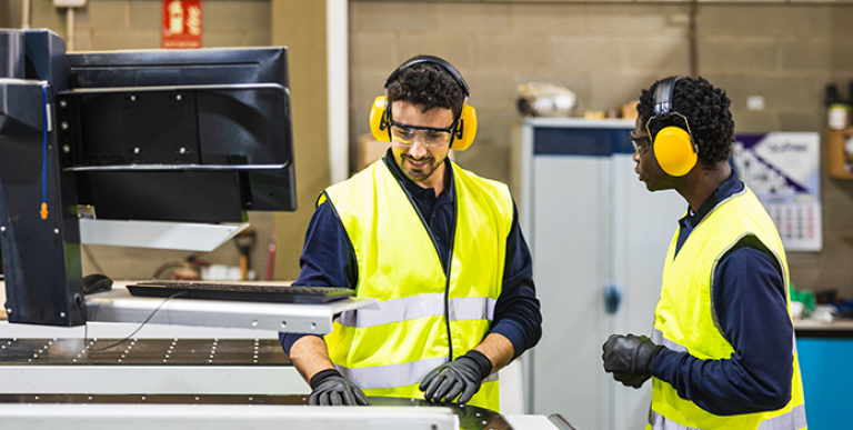 employee-working-ear-protection-safety-vest-696x385
