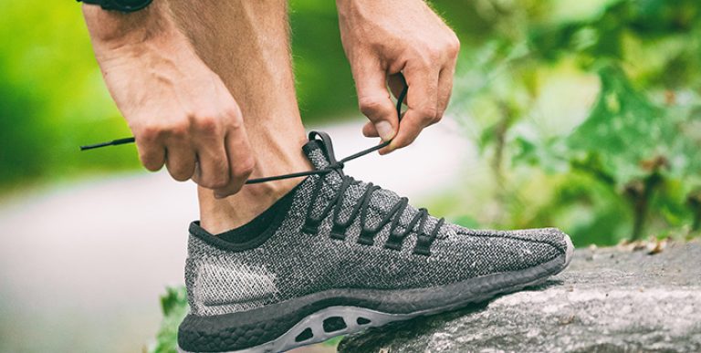 An aging worker tying his running shoe.