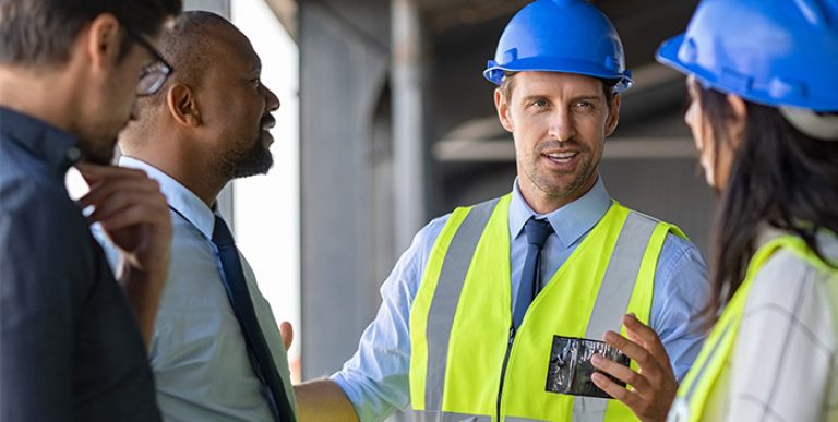A worker conducting a safety meeting while co-workers listen intently.