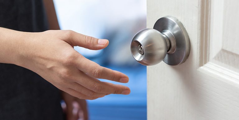A hand about to grab a doorknob.